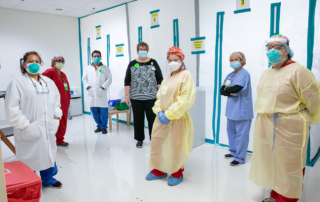 Several people pose for a photo in PPE.