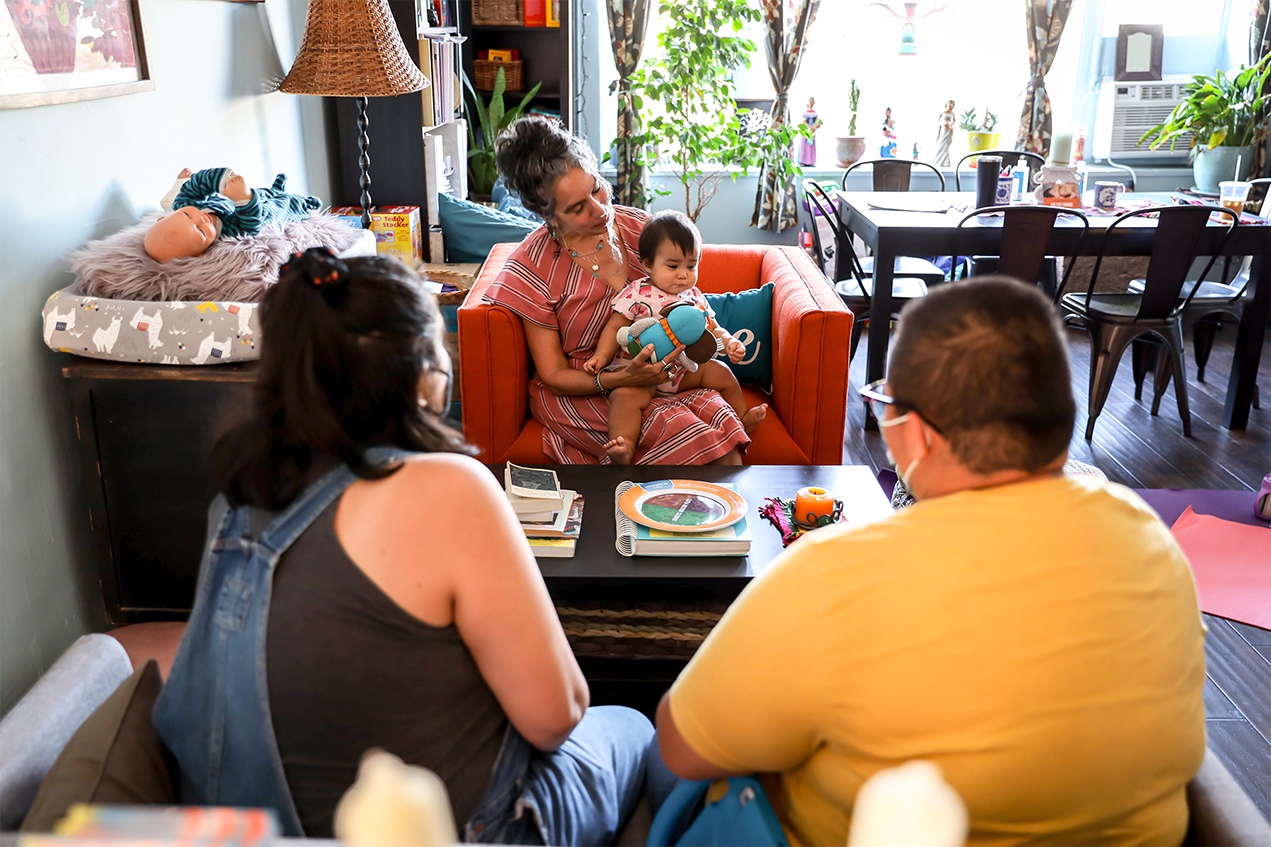 Sarahi Flores, left, and Jessica Johnson, right, meet with Cristina Carlos in New Familia's living room-style setting.