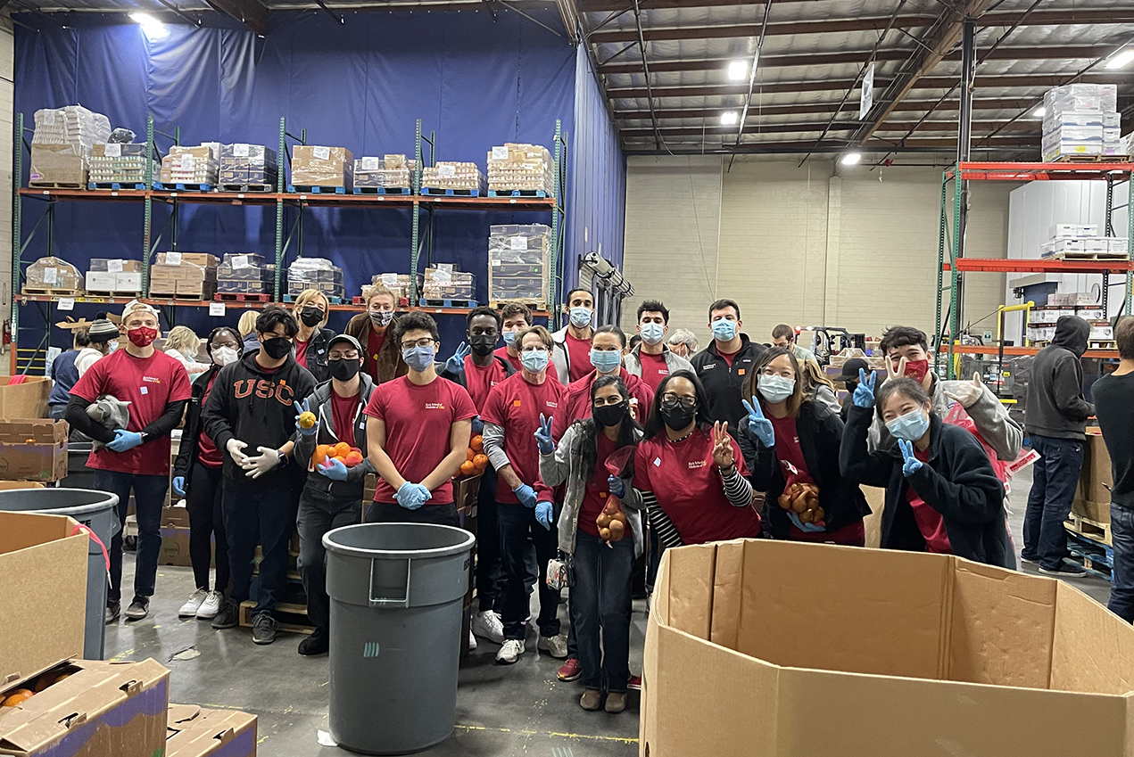 A group of masked young people stand in a warehouse