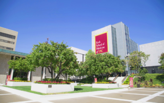 The Keck School of Medicine main building stands beneath a clear blue sky.