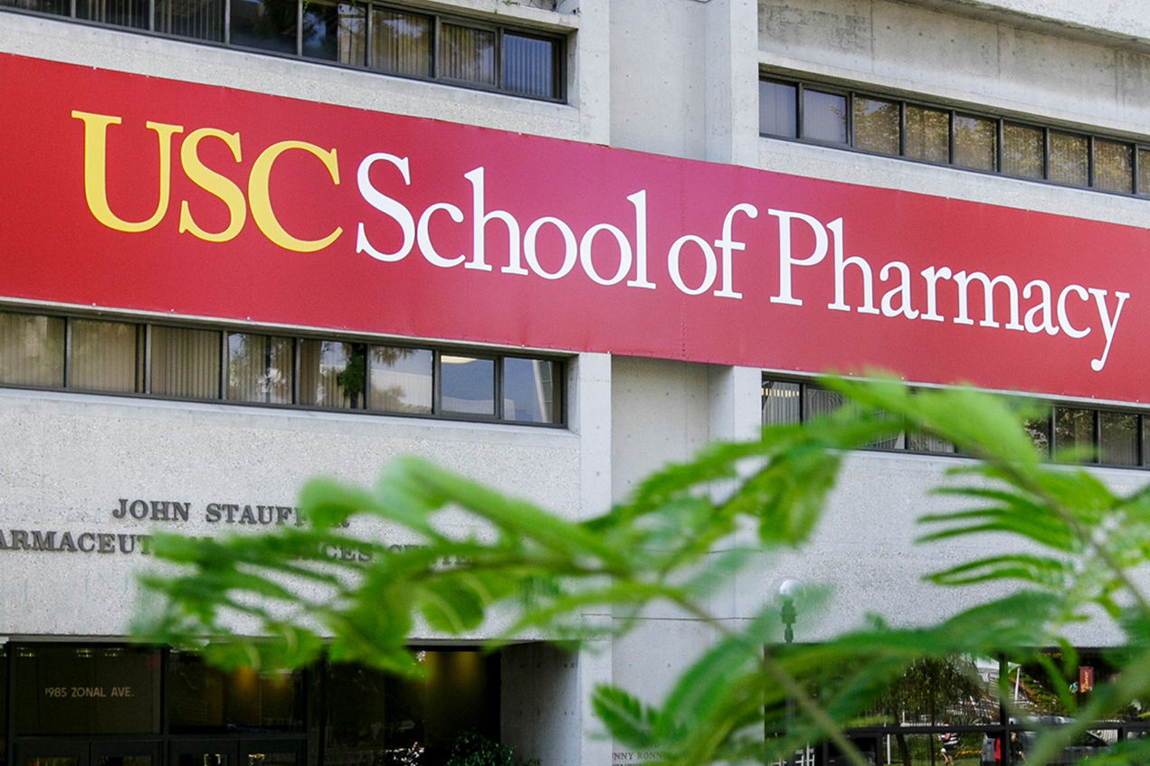 A sign over a building's entrance reads, USC School of Pharmacy