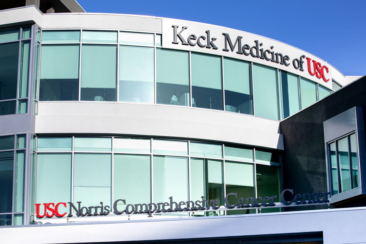 A sleek, sunlit building reads, Keck Medicine of USC: USC Norris Comprehensive Cancer Center