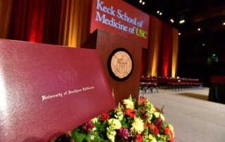 A beautifully cased diploma stands on a bouquet near a podium