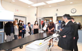 A group of people stand around a diagnostic machine