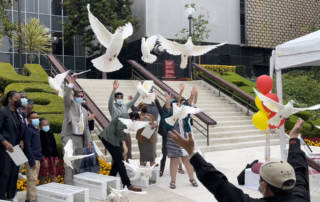 About a half-dozen people release doves into the air.