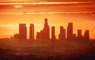The Los Angeles skyline shows bright sun and haze