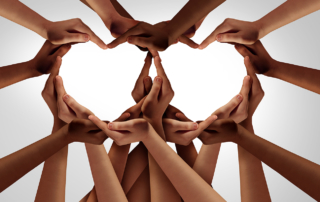 Hands of all races come together to form the shape of two hearts.