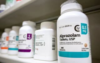 Prescription bottles of benzodiazepines line a pharmacy shelf