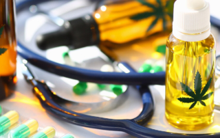 A stethoscope rests among cannabis pills and tinctures