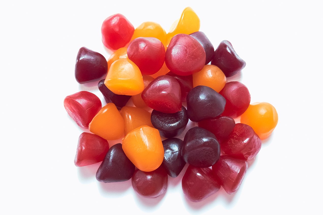 A pile of gummies rests on a white surface
