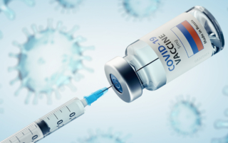 A syringe withdraws COVID-19 vaccine from a vial.