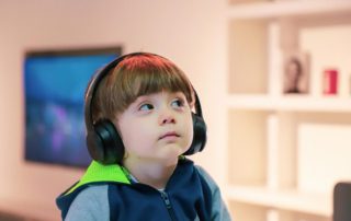 A small child gazes off while wearing headphones