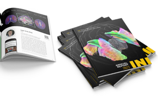 An open, magazine-style report lies next to a stack of closed reports with a brain image on the cover.