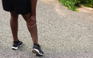 A waist-down photo shows a black man in athletic gear clutching his calf