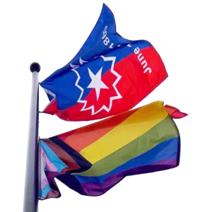 At the top of a flag pole, the Juneteenth flag and the Pride flag billow in the wind.