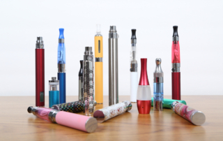 An array of electronic cigarettes stands on a wooden surface