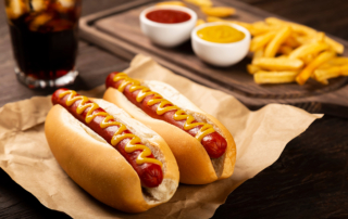 A hot dog with fries and a dark, iced drink