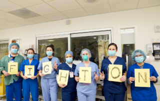 A team of providers from Keck Hospital of USC hold up letters spelling out, "Fight on."