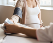 A doctor takes a pregnant woman's blood pressure, which could predict her risk of future hypertension