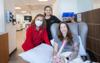 From left to right: Susana Victoria, RN, and Pamela Ann French, RN, present Keck Medicine Infusion patient and mother Jennifer Nunnery with a Mother's Day rose.