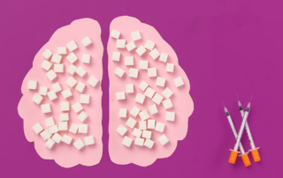 A cutout of a brain covered in sugar cubes beside three hypodermic needles of insulin represents the effect of diabetes on brain health