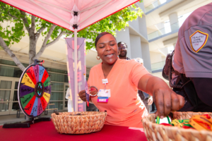 A woman celebrates Juneteenth at a booth offering swag and prizes